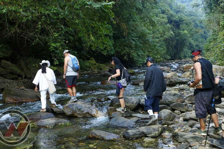 guía indígena cruzando rio con turistas